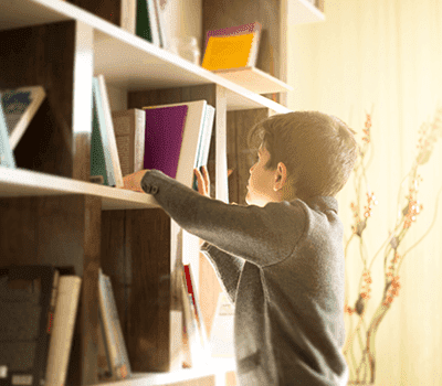 menino escolhendo livro no cantinho da leitura dicas de como fazer em casa