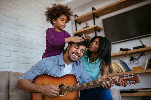Imagem de uma família tocando violão